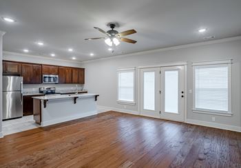A kitchen with wooden cabinets and a white island at Cedar Crest Apartments, Farmington 72730